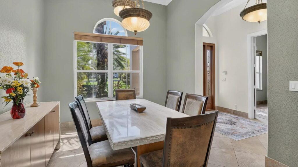 Formal dining room with arched window and tile flooring
