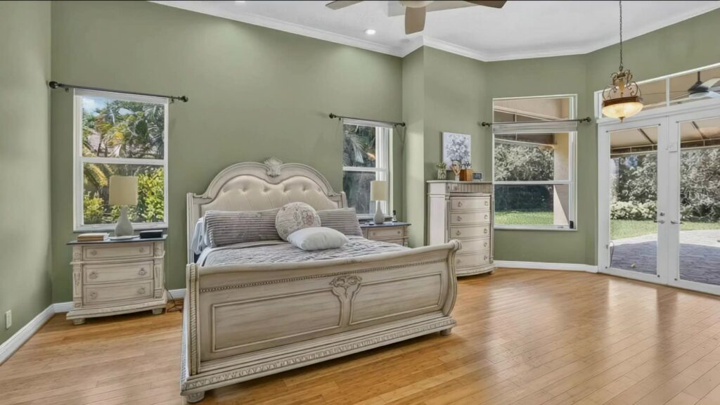 Ground floor primary bedroom with hardwood floors, bay window and French doors to the patio