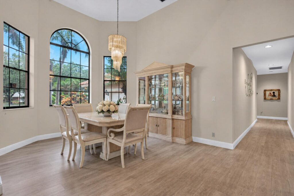 Formal dining room with tall arched windows and a chandelier