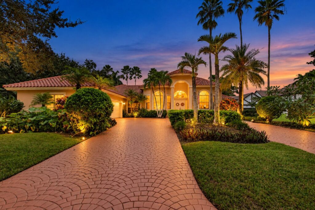 Circular paver driveway and lit front entry at dusk, 10240 Vestal Court