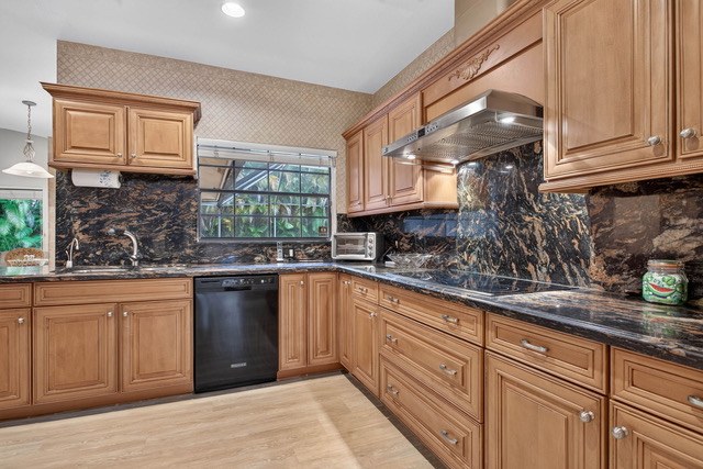 Kitchen with granite counters, custom wood cabinetry and a vented hood