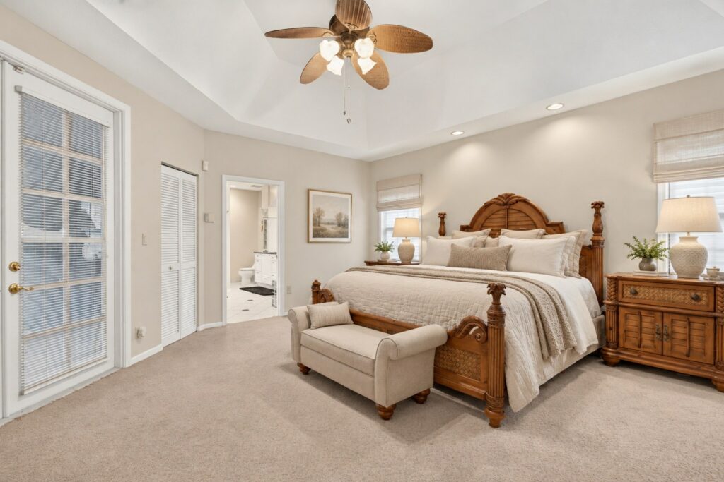 Primary bedroom with a tray ceiling, ceiling fan and French door, decor digitally refreshed