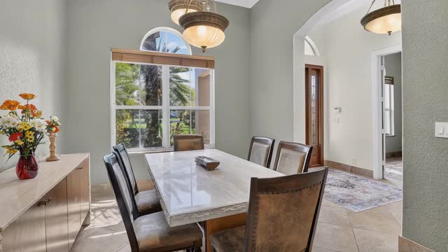 Formal dining room with arched window and tile flooring